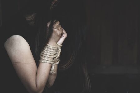 victim woman with hands  tied up with rope in emotional stress and pain.Concepts of violence against...
