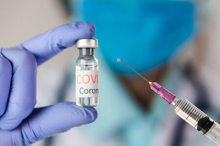 The doctor holding  a vaccine to prevent the Covid-19 virus. novel coronavirus 2019.の写真素材