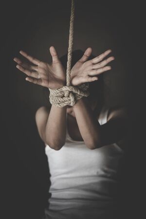 victim woman with hands  tied up with rope in emotional stress and pain.Concepts of violence against...