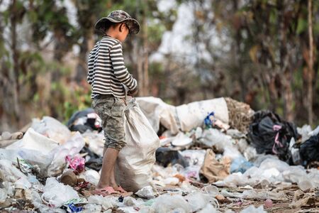 Poor children collect garbage for sale.and recycle them in landfills, the lives and lifestyles of the poor, Child labor, Poverty and Environment Conceptsの写真素材
