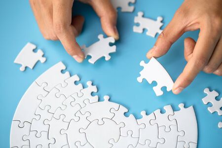 Businessman hand connecting jigsaw puzzle, Business solutions,  target, success, goals and strategy conceptsの写真素材