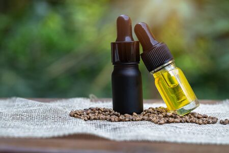 CBD hemp oil  products,  Cannabis oil against Marijuana plant. Herbal Treatment, Alternative Medicineの写真素材