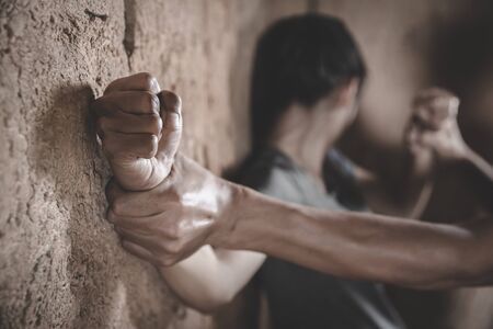 Image for rape and sexual abuse concept.Sexual abuse is a problem or Social issues concept. male hand holding a woman hand for rape and sexual abuse. Human rights violations.の写真素材