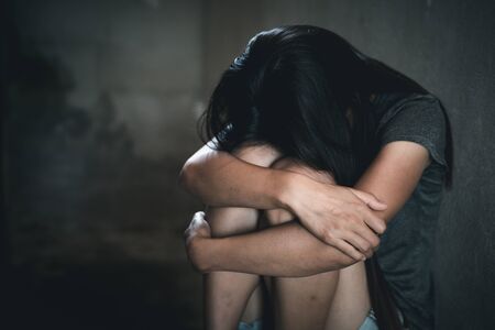 Young depressed woman, domestic and rape violence,beaten and raped sitting in the corner,  Copy space.  International Women's Dayの写真素材