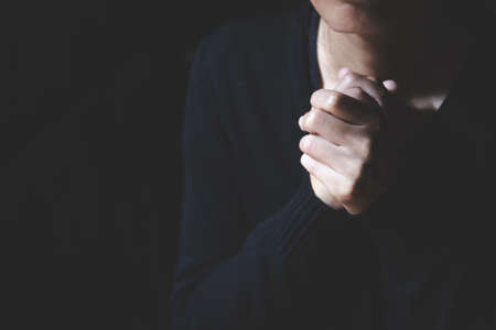 Christian woman praying worship hands with faith in religion and belief in God on dark background.の写真素材
