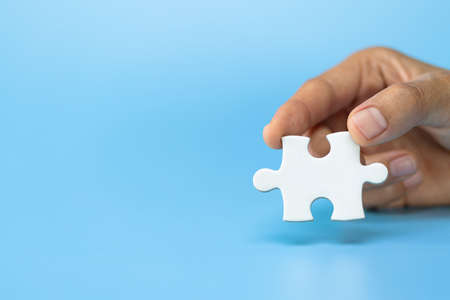 business woman hand holding  jigsaw puzzle piece, Business solutions, goals and strategy concepts.の写真素材