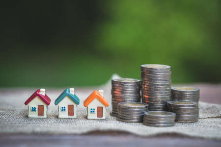 coin stack with house model, savings plans for housing ,financial concept,Concept of real estate...