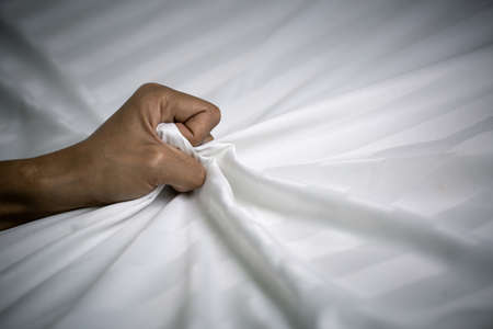 Women's hands crumpled sheets,  concept photo of Sexual assault, Woman violence and rape concept.の写真素材