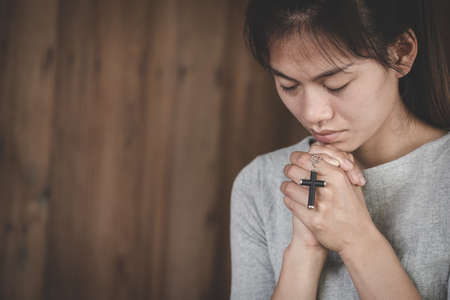 Women pray to God with the  cross. Woman Pray for god blessing to wishing have a better life. Christian life crisis prayer to god.の写真素材