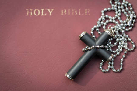 Closeup of simple Christian cross necklace on Bible. Concept for Christian, Christianity, Catholic...