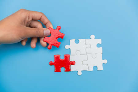 Jigsaw connection between white and red jigsaw puzzles, Jigsaw puzzle in the hand of a businessman, ...
