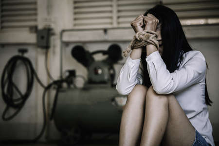 Hands tied up with rope of a missing kidnapped, abused, hostage, victim woman in pain, Human trafficking and rape concepts.の写真素材