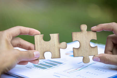 Two hands of businessman to connect couple puzzle piece. symbol of association and connection. business strategy.の写真素材