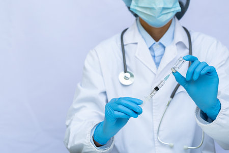 Doctor or scientist in laboratory holding a syringe with liquid vaccines. Concept fight against virusの写真素材