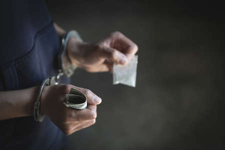 Drug dealer under arrest confined with handcuffs.   Anti drug.  Drug concept.