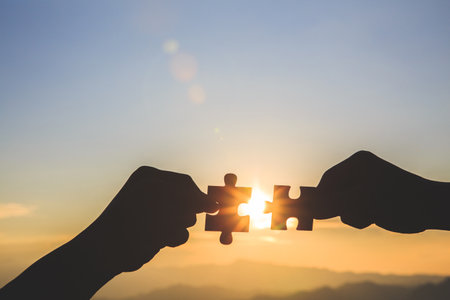 Two hands of businessman to connect couple puzzle piece. symbol of association and connection. business strategy.の写真素材