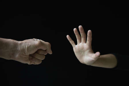 Violent young man threatening his girlfriend with his fist. Domestic violence concept, stop violence against Women.の写真素材