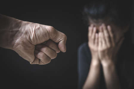A man's hand will hurt a woman. Domestic violence and harassment of women. International Women's Day.の写真素材