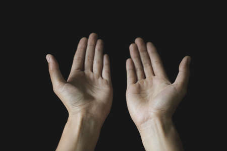 Praying hands. Black background. Make a wish in God. Faith in religion and belief in God on the power of hope or love and devotion.の写真素材