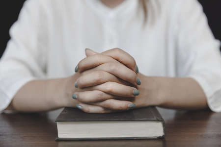 The hand placed on the Bible is asking for blessings. Pray to God. Praying for spiritual beliefs....