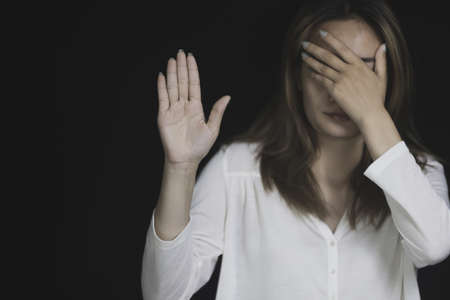 A woman hiding face. Stop violence against women concept.の写真素材