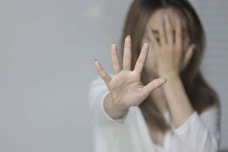 Close up of young woman show stop gesture sign by hand saying no to domestic violence or abuse