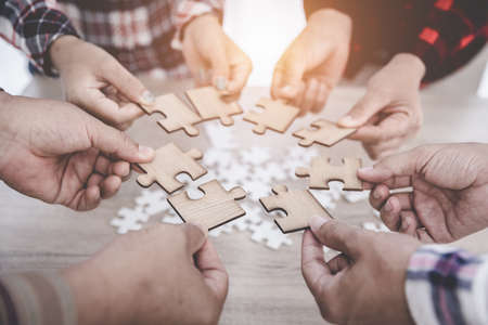 Group of business people assemble jigsaw puzzles, concepts of cooperation, teamwork, help and support in business, symbol of association and connection. business strategy.の写真素材