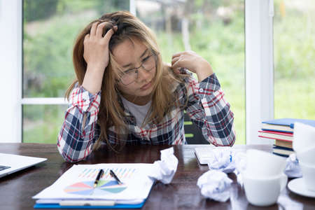 Work Failure Concept, Business Woman Having Headache While Working Using Laptop Computer. Stressed And Depressed Girl Touching Her Head, Feeling Pain While Sitting At Wooden Table.の写真素材