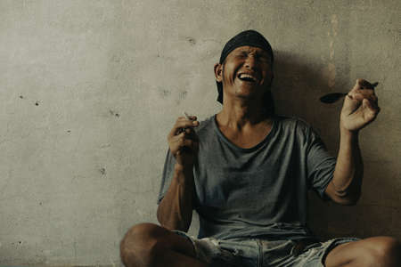 Drug addict man with hallucinations, Drug addict man with syringe using drugs.