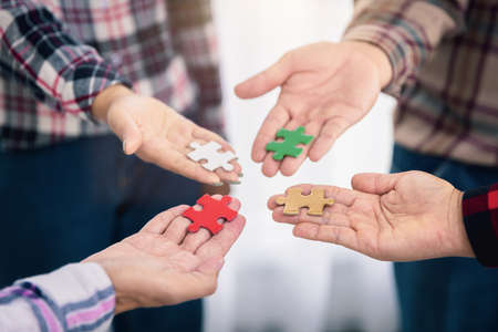 A group of business people assembling jigsaw puzzle.  Successful teamwork in finding business solutions.The concept of cooperation,  help and support in business.の写真素材