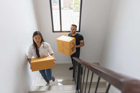 A couple with a big box in their new home. Carrying things into a new homeの写真素材