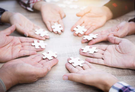 Hands of diverse people assembling jigsaw puzzle, Youth team put pieces together searching for right match, help support in teamwork to find common solution concept, top close up viewの写真素材