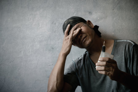 Stop drug addiction concept. A human hand holding a needle for heroin . International Day against Drug Abuse.の写真素材