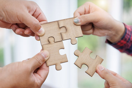 Group of business people assembling jigsaw puzzle and represent team support and help concept