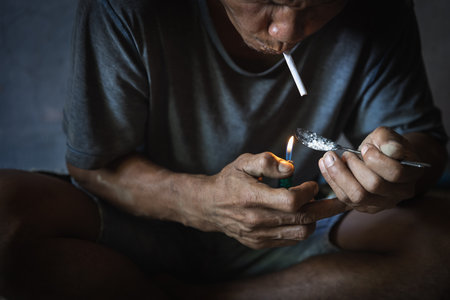 A junkie prepares pills with a spoon, lighter, heroin and syringes. international anti-drug day, social hazards, fight against drugsの写真素材