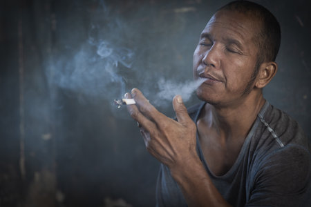 man smoking a cigarette. Cigarette smoke spread. Smoking cessation conceptの写真素材