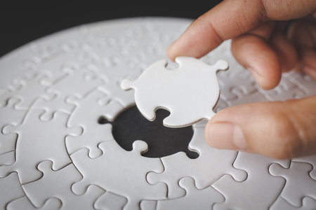Hand put the last piece of jigsaw puzzle to complete the mission. Completing final task, missing...