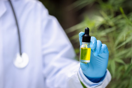 Drip hemp oil into a glass bottle. CBD oil. Cannabis. Alternative medical concepts. Scientific research. Medical education and research.の写真素材