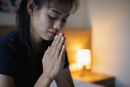 A woman folded her hands, praying for blessings and praying to God. Praying for spiritual beliefs. The power of hope or love and loyalty. Faith in goodness.の写真素材
