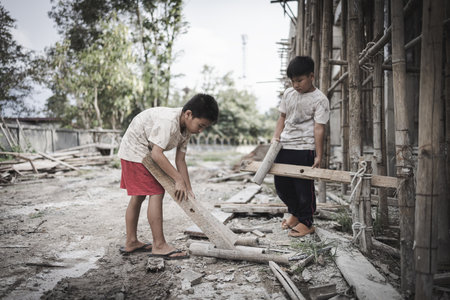Poor children are forced to work in construction. are forced to work in the construction area. Human rights concepts, stopping child abuse, violence, fear of child labor and human trafficking.の写真素材