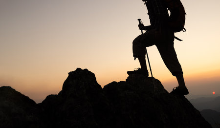 silhouette male hikers climbing up mountain cliff . Climbers on a mountain ridge.の写真素材