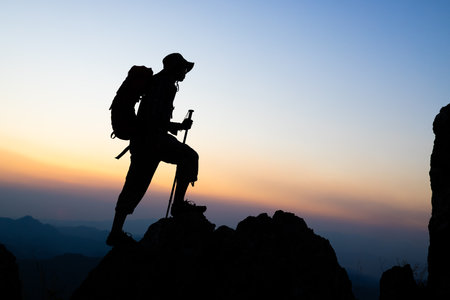 Silhouette of  climbers ascending a rugged mountain,  people on peak mountain climbing helping team work , travel trekking success business concept.の写真素材