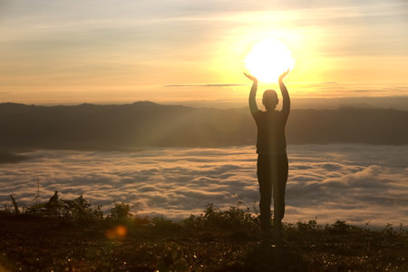 Silhouette of woman  praying over beautiful sunrise background, beautiful landscape, pay homage, spirituality and religion,man praying to god. Christianity concept.の写真素材