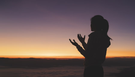 Silhouette of Religious young woman praying to God in the morning, spirtuality and religion,  Christians and Bible study concept.の写真素材