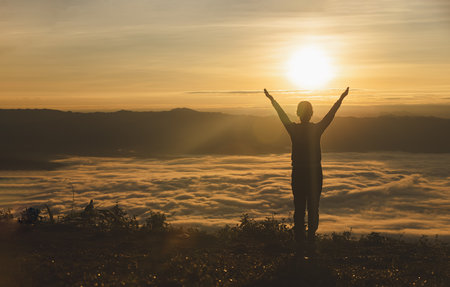 Man rise hand up on top of mountain and sunset,  Freedom and travel adventure concept.の写真素材