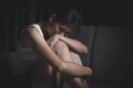 Blurred image of a woman sitting on the corner of a sofa.の写真素材
