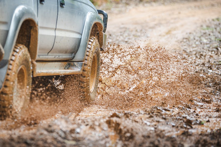 Off-road vehicles driving on muddy tracks. Mud and water splash in off-road racing. Offroad car...