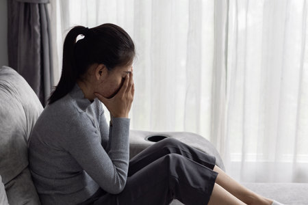 Asian woman sitting on the house area Feeling sad, tired and worried about depression, mental health problems and heartbreaking concept.の写真素材