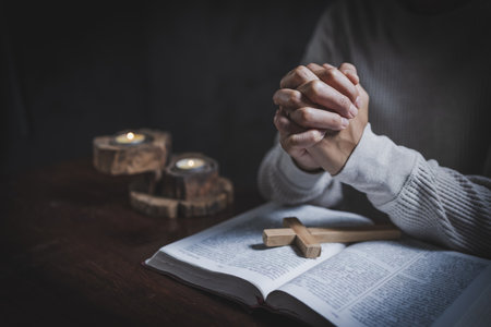 Religious concepts, Woman praying with hands on a bible.
