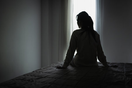 Silhouette of a woman in the bedroom, feeling sad tired and worried suffering depression in mental health. in concept of depression anxiety and insomniaの写真素材